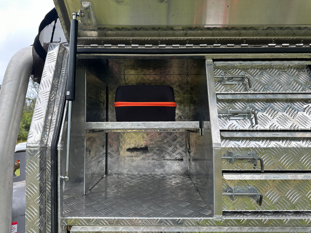 Compact Boost N’ Inflate case neatly stored inside a ute tray aluminium checker plate toolbox, taking up minimal space compared to bulky jump starters and air compressors.