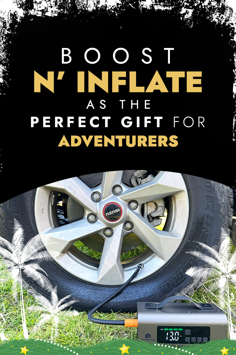 A banner featuring the Boost N’ Inflate product. The top section has bold text reading “BOOST N’ INFLATE AS THE PERFECT GIFT FOR ADVENTURERS.” The words “N’ INFLATE” and “ADVENTURERS” are highlighted in gold. The bottom half shows a close-up of a car tire being inflated with the Boost N' Inflate device, which is placed on grass. The device’s display screen is visible, showing the current pressure reading. The background includes festive white feather-like graphics and small stars for decoration.