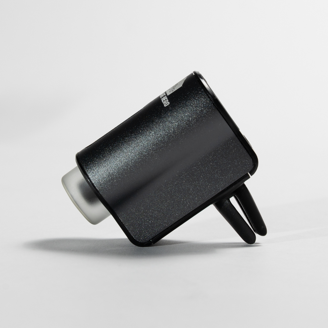 Car Diffuser – Premium Fragrance shown in a white studio setup, angled to display the sleek black metal casing, dual air vents, and compact clip-on design.