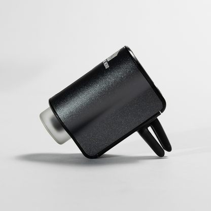 Car Diffuser – Premium Fragrance shown in a white studio setup, angled to display the sleek black metal casing, dual air vents, and compact clip-on design.