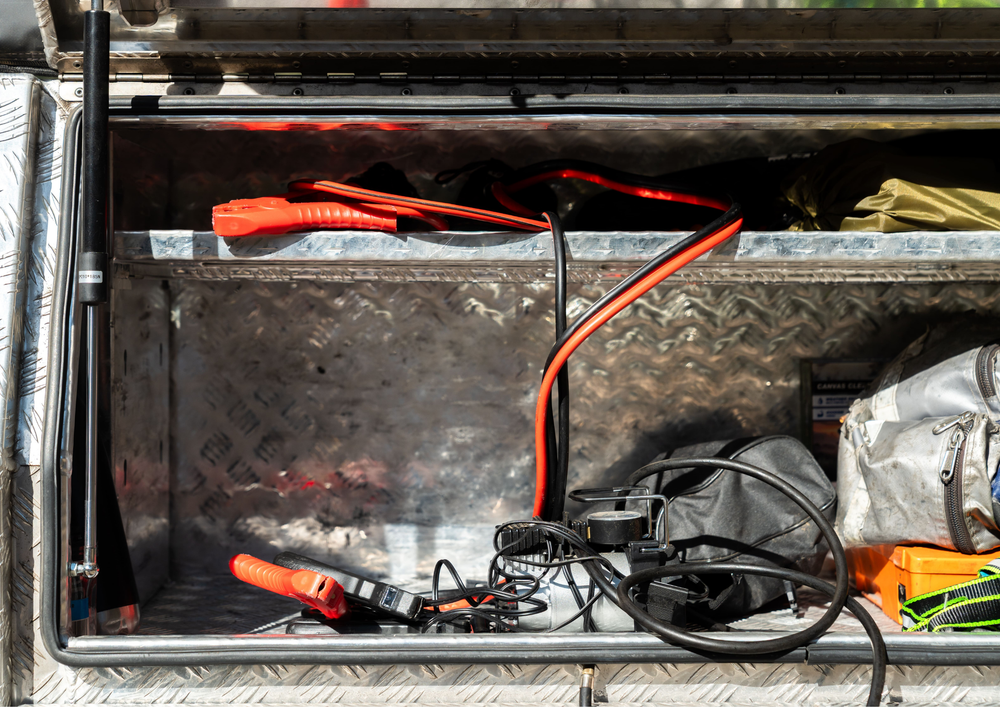 Truck bed with tools and equipment scattered inside looking disorganised.