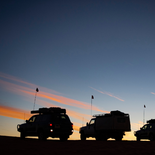 Silhouetted off-road vehicles at sunset used in My Garage Hero image banner for jump starter spare parts.
